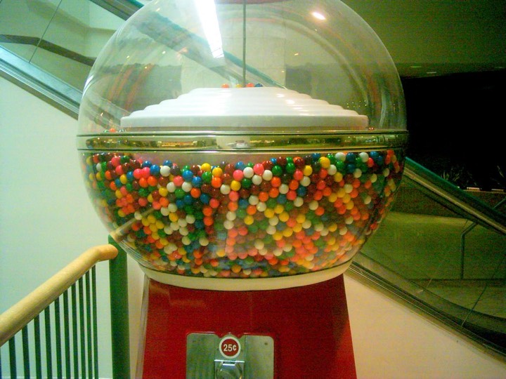 A giant gumball machine globe full of gumballs above a 25-cent coin slot
